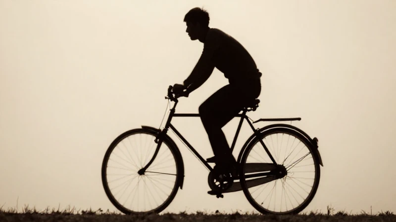 Bicicleta antigua, ciclista silueteado, tono sepia nostálgico