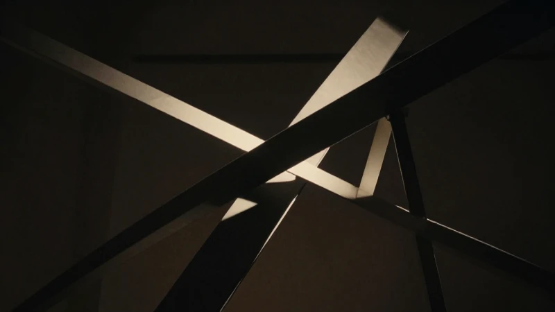 Escultura abstracta, líneas entrelazadas e iluminación dramática